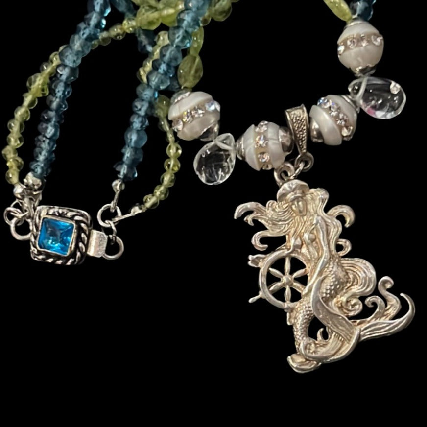 Captain of her own ship, this exquisite silver mermaid is a Buzzwinkle's exclusive on a peridot, topaz, pearl, and aquamarine double chain.