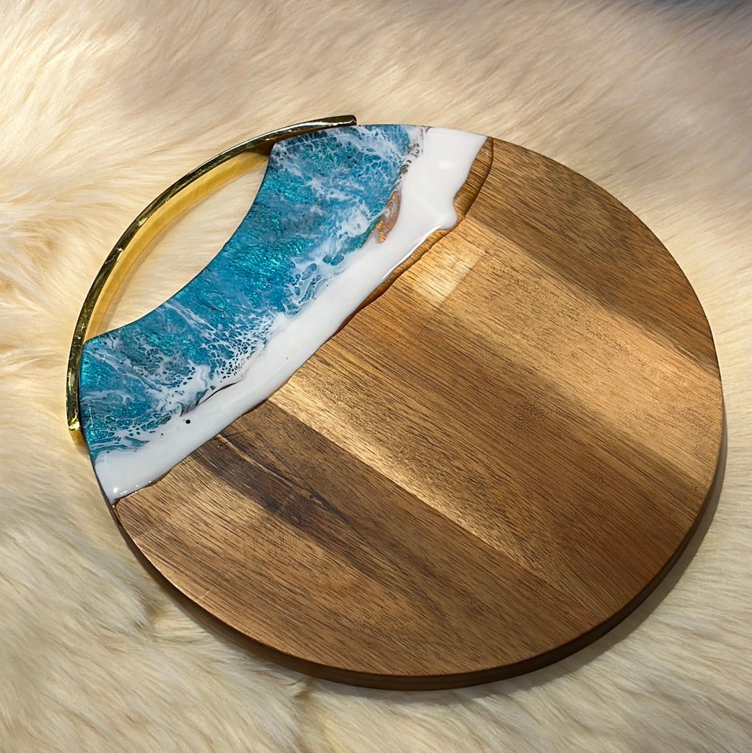 Round wooden cheese board with "Ocean" resin finish.