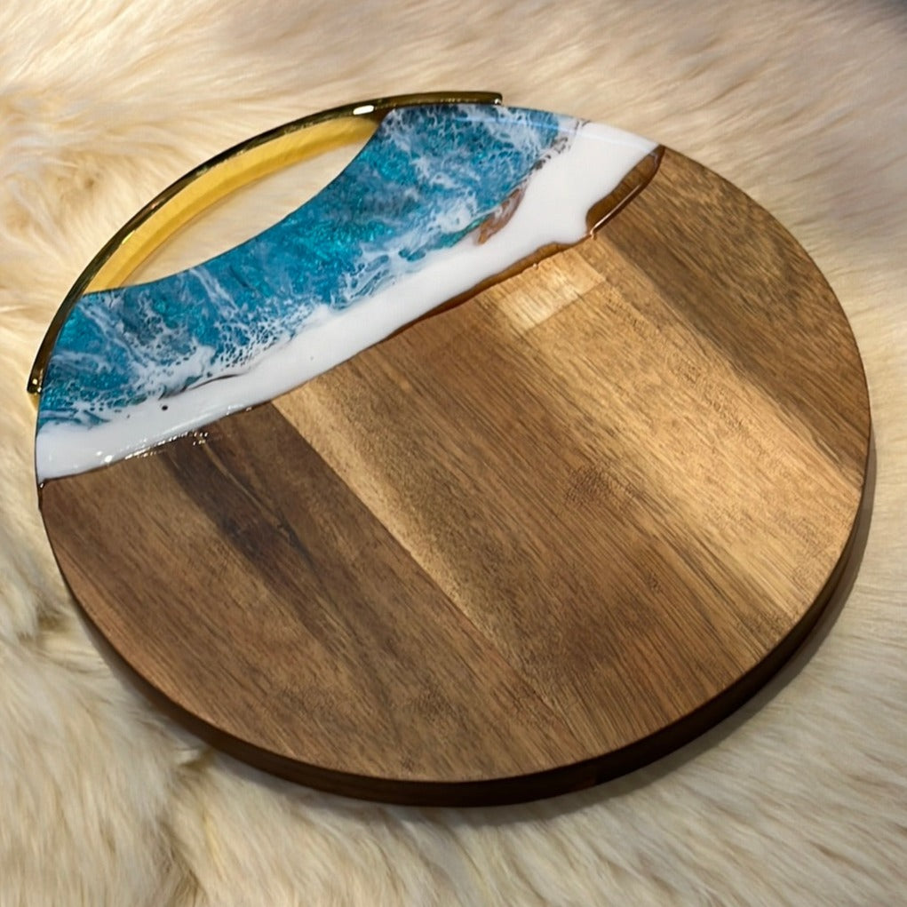 Round wooden cheese board with "Ocean" resin finish.