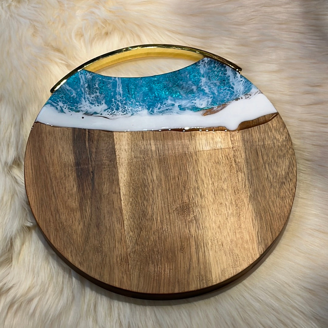 Round wooden cheese board with "Ocean" resin finish.