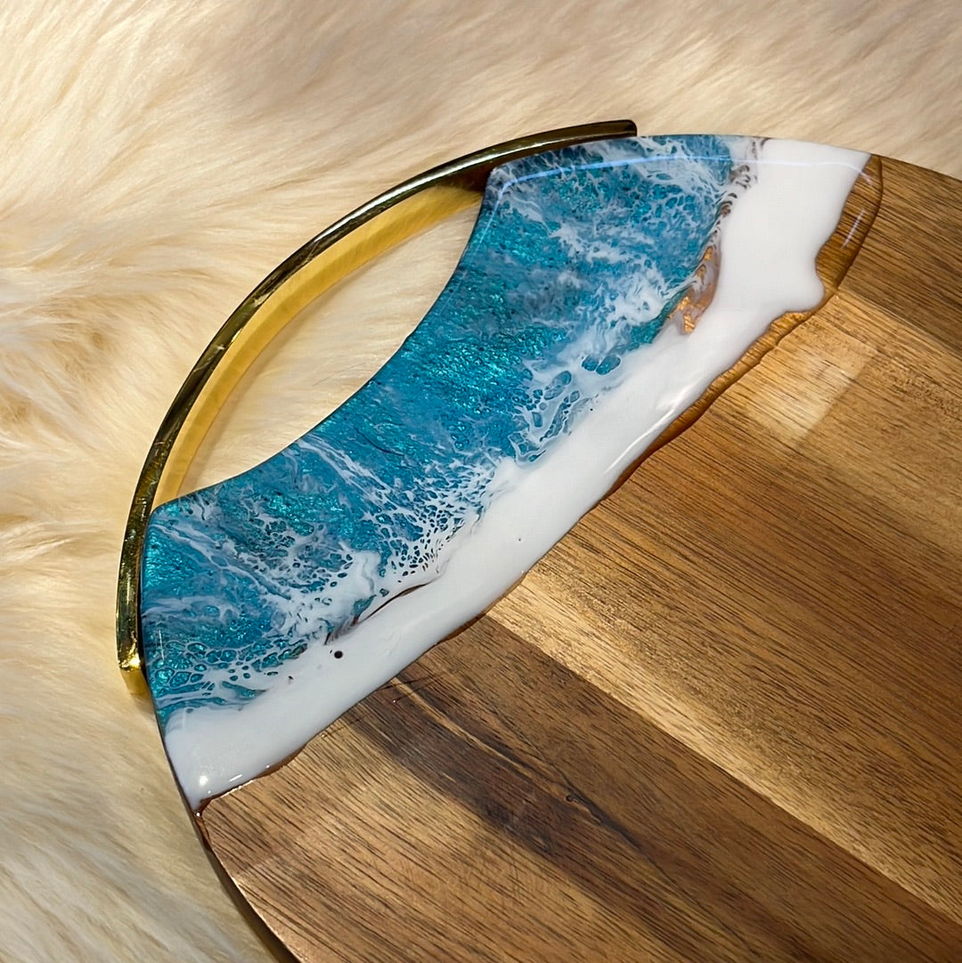 Round wooden cheese board with "Ocean" resin finish.