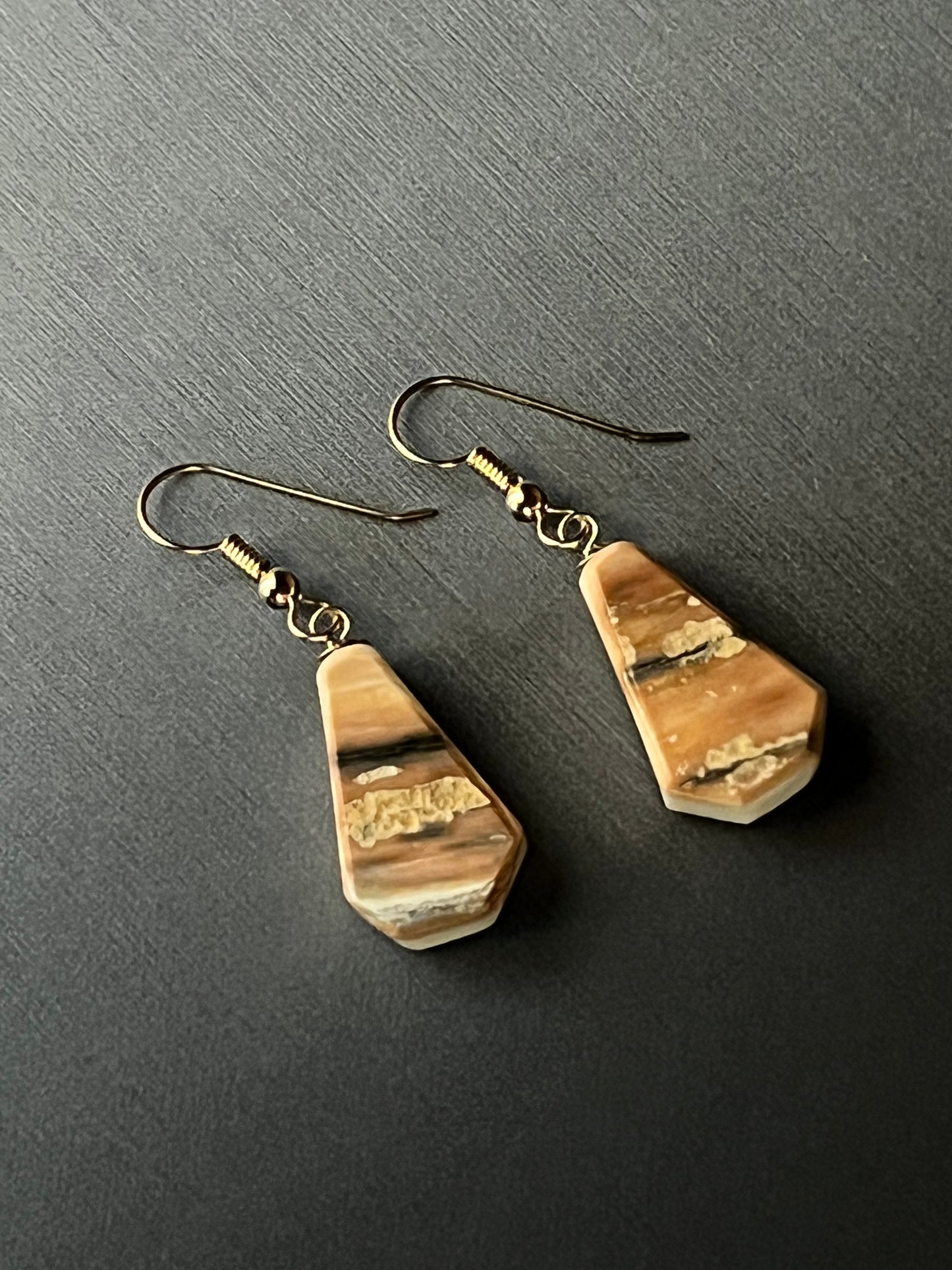 Reversible mammoth ivory earrings in 14k gold. This unique piece of jewelry is authentic Alaska Native art created by an enrolled member of an Alaska Native tribe. Certified Silver Hand and Made in Alaska jewelry.